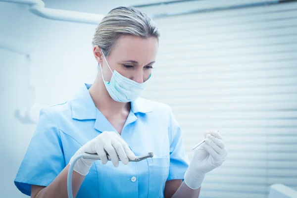 Kadın dişçi diş araçları tutarak ameliyat maskesi — Stok fotoğraf