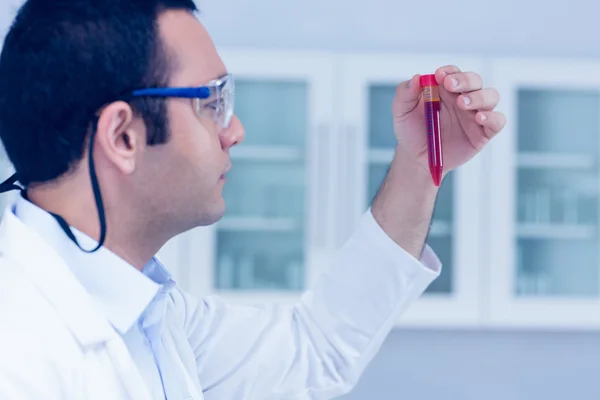 Science student holding up vial — Stock Photo, Image