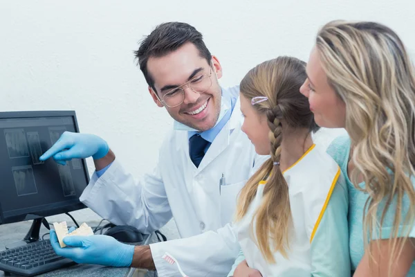 Dentiste avec assistant montrant petite fille sa bouche radiographie — Photo