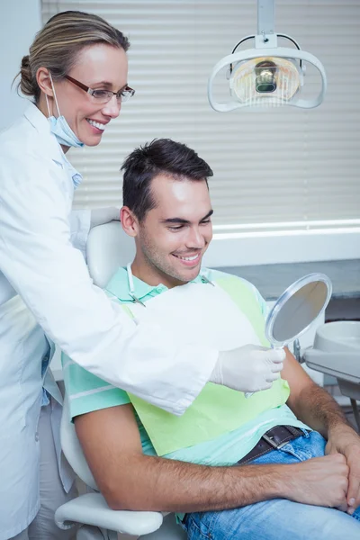 Jovem sorridente olhando para o espelho — Fotografia de Stock