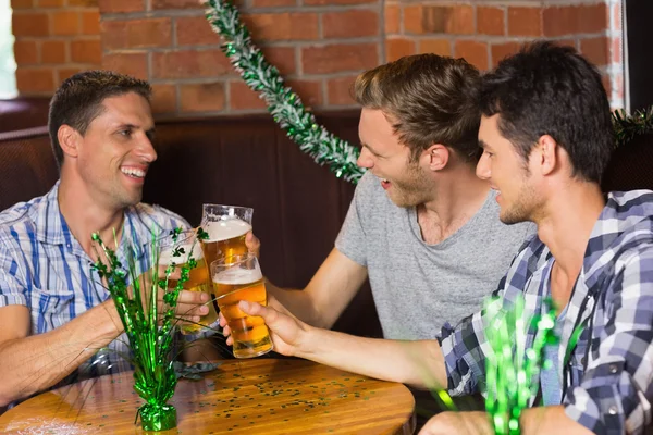 Heureux amis griller avec des pintes de bière sur patricks jour — Photo