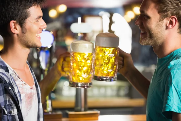 Happy friends toasting with jugs of beer — Stock Photo, Image