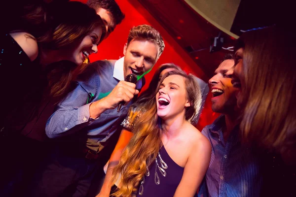 Happy friends singing karaoke together — Stock Photo, Image