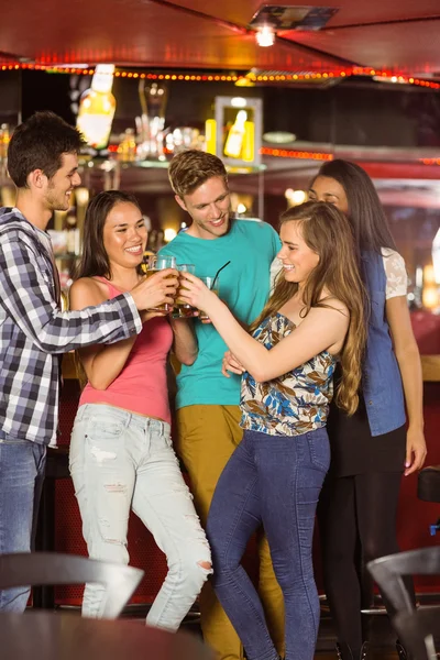 Smiling friends drinking beer and mixed drink — Stock Photo, Image