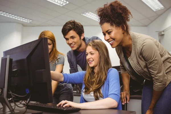 Estudante alegre apontando para o computador — Fotografia de Stock