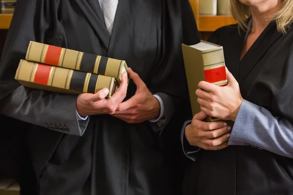 Адвокаты, держащие книги в библиотеке — стоковое фото