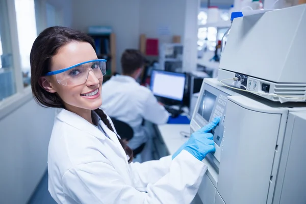 Lachende jonge scheikundige gebruik van de machine — Stockfoto