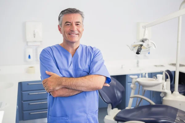 Retrato de un dentista amigable con los brazos cruzados — Foto de Stock