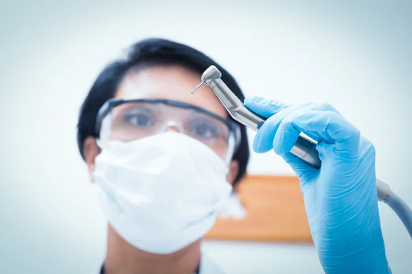 Dentista femenina en máscara quirúrgica que sostiene taladro dental —  Fotos de Stock