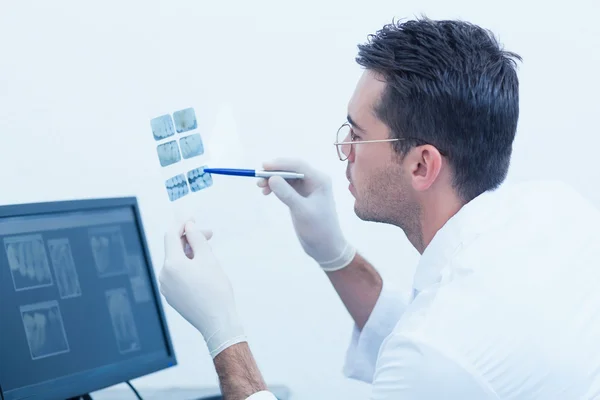 Concentrated male dentist looking at x-ray — Stock Photo, Image