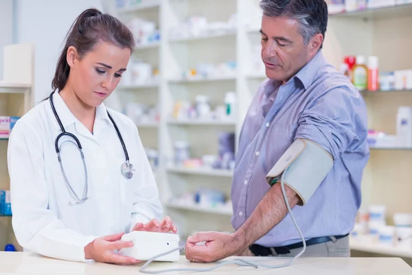 Joven aprendiz tomando presión arterial — Foto de Stock