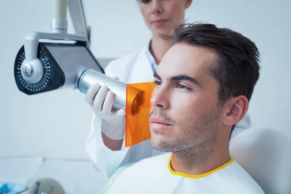 Serious young man undergoing dental checkup — Stock Photo, Image