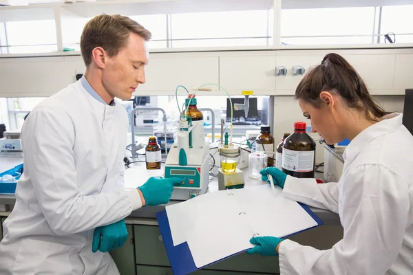 Jóvenes científicos realizando un experimento juntos — Foto de Stock