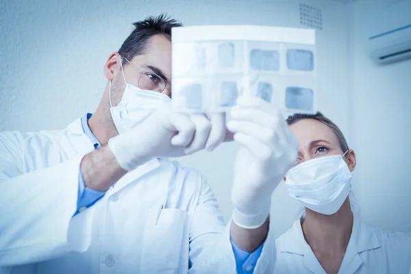 Dentists looking at x-ray — Stock Photo, Image