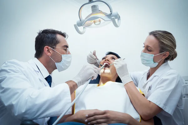 Dentista com assistente examinando os dentes das mulheres — Fotografia de Stock