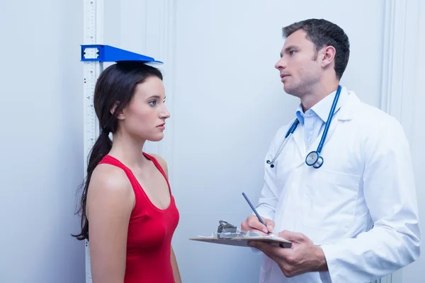 Selbstbewusster Arzt misst die Körpergröße der Patienten — Stockfoto