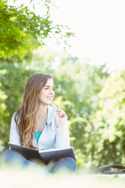 Student zitten denken en het boek bedrijf — Stockfoto