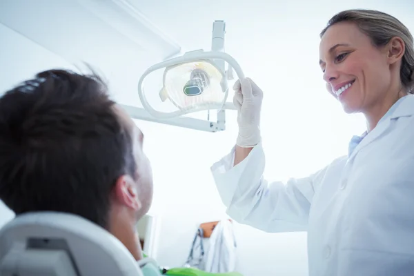 Dentista femminile esaminando denti mans — Foto Stock