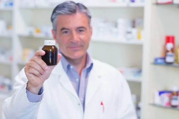 Farmacêutico mostrando uma garrafa de medicamento — Fotografia de Stock