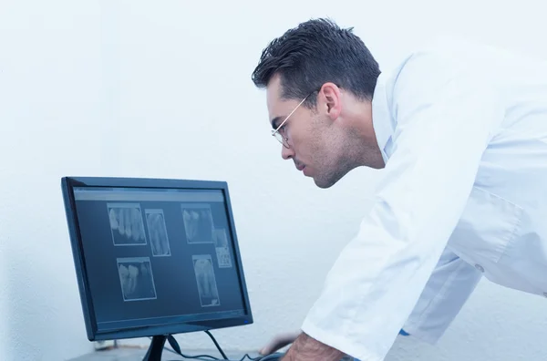 Dentist looking at x-ray on computer — Stock Photo, Image