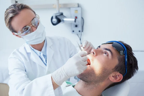 Dentista femenina examinando los dientes mans — Foto de Stock