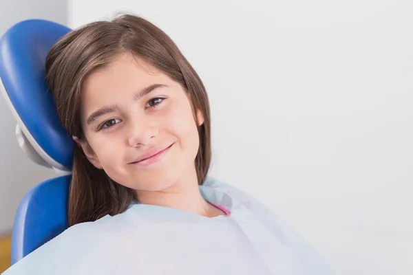 Smiling young patient sitting in dentists chair — Stock Photo, Image