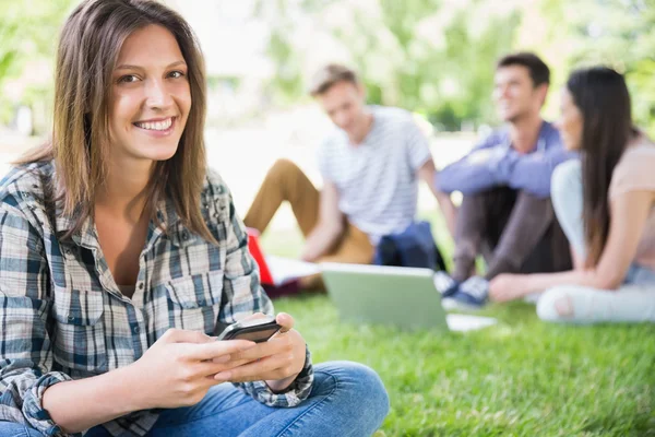 Happy students sitting outside on campus — Stock Photo, Image