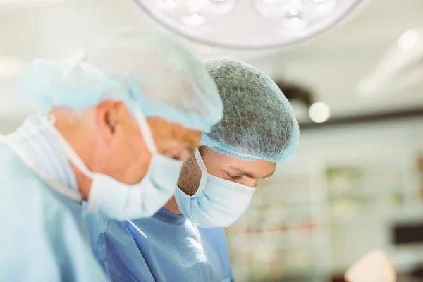 Older surgeon teaching new surgeon how to operate — Stock Photo, Image