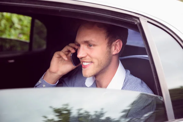 Mladý muž mluví telefonu v limuzíně — Stock fotografie