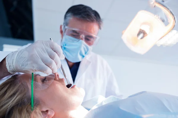 Dentista che esamina un paziente denti — Foto Stock