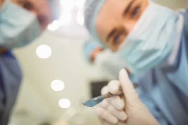 Молодые хирурги держат скальпель — стоковое фото