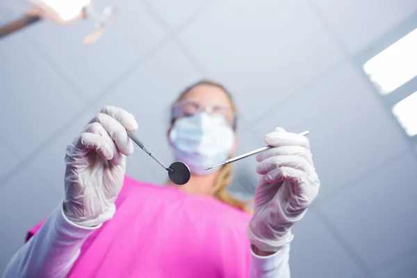 Dentista em máscara cirúrgica segurando ferramentas sobre o paciente — Fotografia de Stock