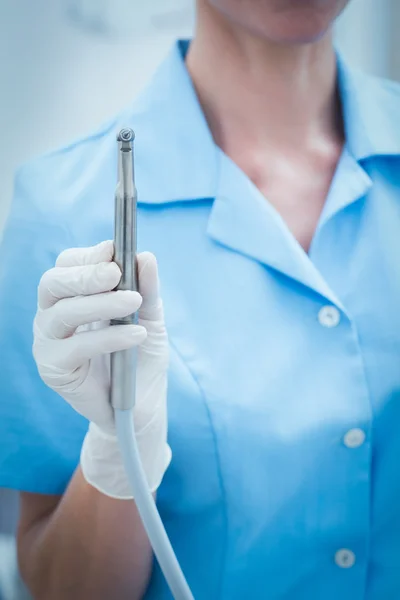 Mid section of dentist holding dental drill — Stock Photo, Image