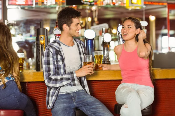 Smiling friends drinking beer together — Stock Photo, Image