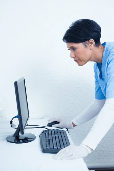 Female dentist looking at computer monitor — Stock Photo, Image