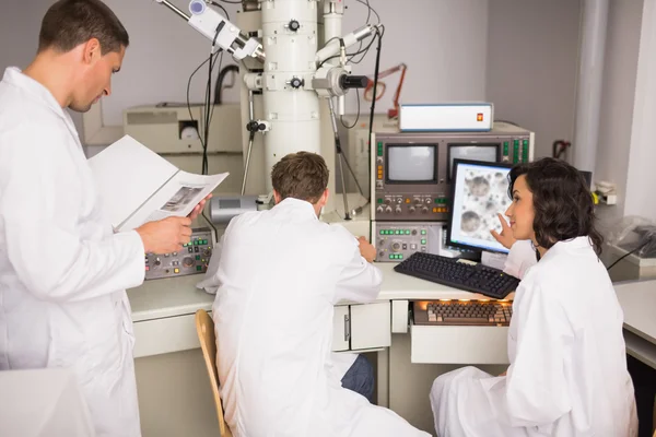 Estudantes de bioquímica usando microscópio grande — Fotografia de Stock