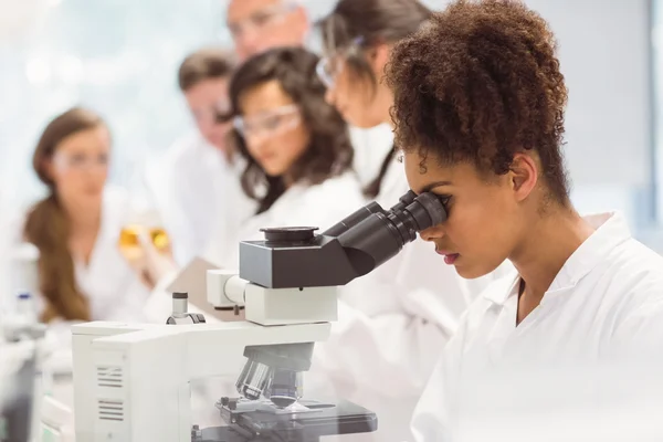 Estudante de ciência olhando através do microscópio no laboratório — Fotografia de Stock