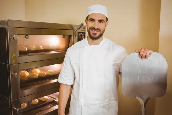 Baker smiling at camera beside oven — Stock Photo, Image