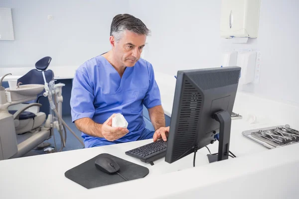 Seriöser Zahnarzt mit Computer — Stockfoto