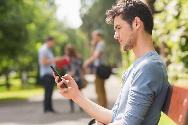 Handsome student sending a text outside — Stock Photo, Image