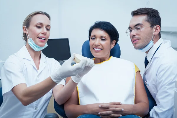 Dentists showing woman prosthesis teeth — Stock Photo, Image