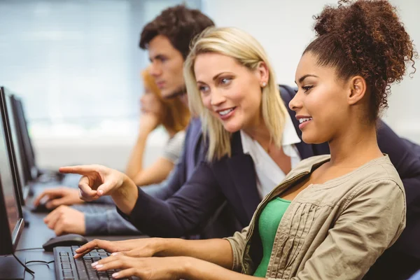 Insegnante attraente parlando con il suo studente in classe di computer — Foto Stock