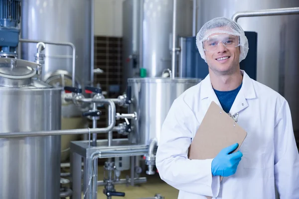 Smiling scientist looking at camera holding a clipboard — Stock Photo, Image