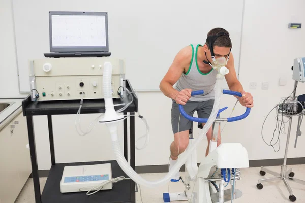 Hombre haciendo la prueba de aptitud en bicicleta estática —  Fotos de Stock