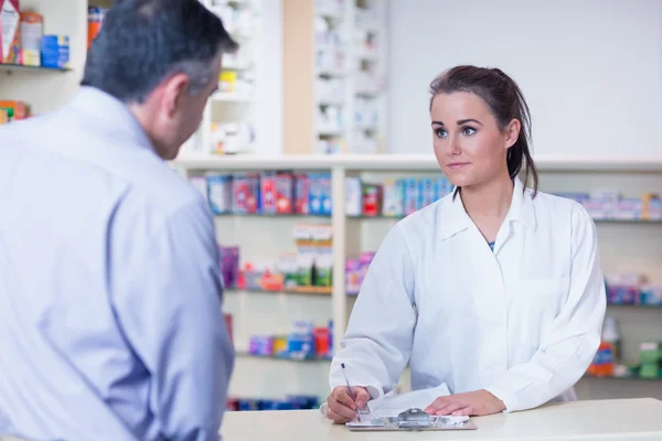 Trainee prescrição escrita na frente de um cliente — Fotografia de Stock