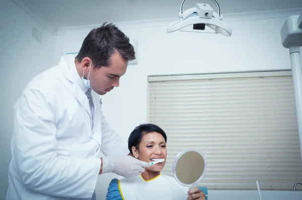 Male dentist brushing womans teeth — Stock Photo, Image