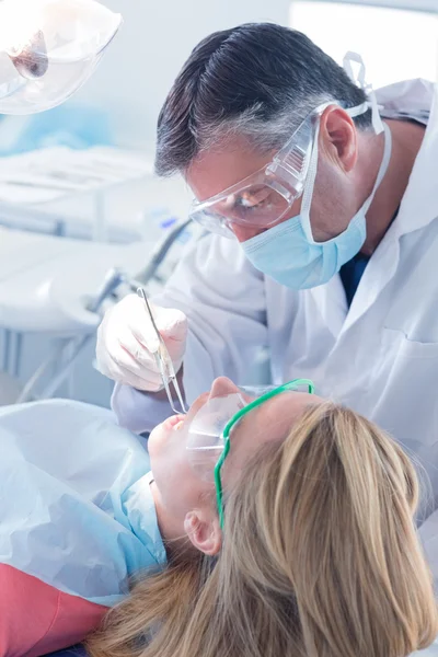 Dentista en máscara quirúrgica y herramienta de sujeción de guantes — Foto de Stock