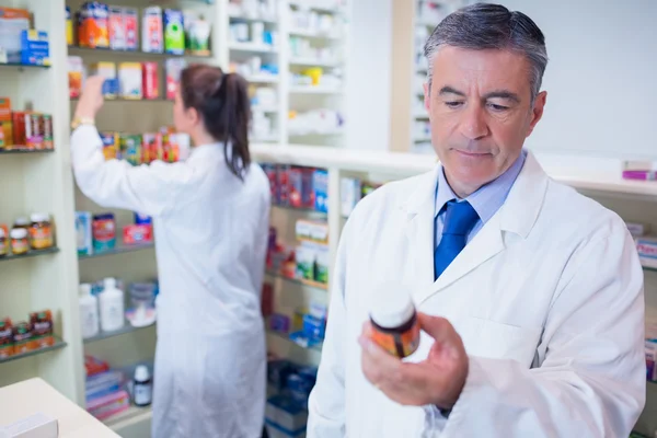 Man met een doos van pillen tijdens het lezen van het etiket — Stockfoto