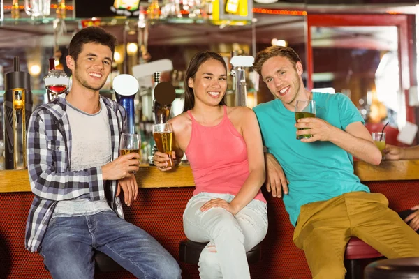 Smiling friends drinking beer together — Stock Photo, Image