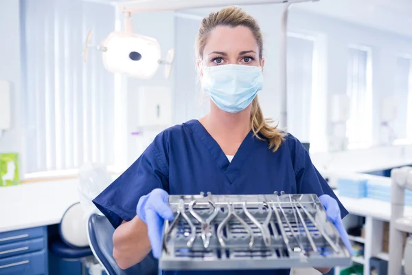 Dentist in blue scrubs holding tray of tools — Stock Photo, Image